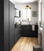Cocina de frentes negros con acabado mate y cubierta de madera